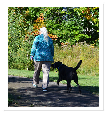 a woman walking a dog outside
