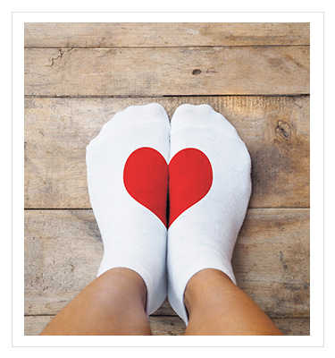 a pair of white socks with a red heart on them